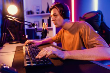 Kazanmak için çevrimiçi oyun oynayan akıllı flama makinesinin sunucu kanalı, neon ışıklı odada seçilen takım yarışması için izleyicilerle birlikte canlı yayında canlı yayında kulaklık takıyor. Bireysel.