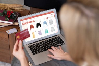 Genç bir kadın internet bankacılığı için kredi kartıyla dizüstü bilgisayar kullanıyor. Evinde online ödeme kapısı ile E ticareti yapıyor. Banka kartıyla modern ve kullanışlı online alışveriş. Blithe