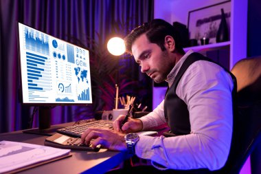 Akıllı iş adamı evrak raporlarını analiz eder, satış çeyreği online kanalı için kar ya da zarar hesaplar ürün servisinde hedef kitle pazar müşterisini neon karanlık ışık odasında karşılaştırır. Tahmin et..