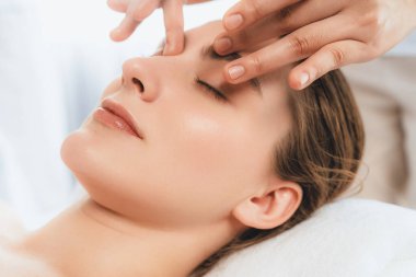 Kafkasyalı kadın stres önleyici kafa masajından ve lüks tatil beldesi ya da otel spa salonundaki modern ışık ortamında yüz güzelliği eğlencelerini şımartmaktan hoşlanıyor. Sessiz.