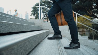 Profesyonel proje yöneticisinin iş yerine giderken elinde çantayla parkta ya da şehirde yürüyen yetenekli bir iş adamı. Büyümeyi temsil et, terfi al, yeteneğini arttır. Sevinçli..