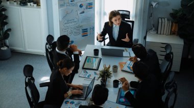 Akıllı yönetici projesinin üst görünümü beyaz tahtaya zihin haritası ve finansal grafik ile işaret ediyor ve çeşitli yatırımcılar hisse yatırım grafiğini dinleyip analiz ederken pazarlama fikrini açıklıyor. Müdürlük.