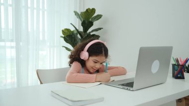 Kulaklık takıp ödevlerini yapan sevimli bir Amerikalı kız. Programlama sistemini araştırırken ve mühendislik komut yazarken defterde yazan mutlu çekici kız öğrenci. Pedagoji.