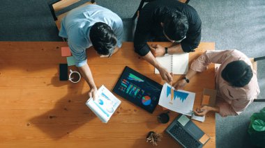 Yönetici, toplantı odasındaki meslektaşlarına mali grafiği açıklar. Farklı pazarlama ekibinin tabletle masada otururken fikir ve planlama stratejisini en üst düzeyde paylaşması. Cemaat.