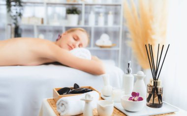 Aromaterapi masajı gündüz atmosferinde ya da spa salonunda bulanık bir kadına odak dekor ve spa aksesuarları kurarak tatil köyünde ya da otel arka planında keyifli aroma spa masajı yapan bir masaj. Sessiz.