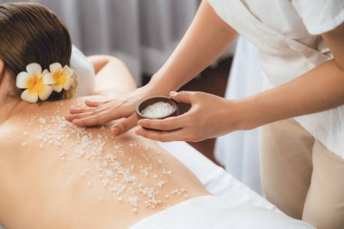 Lüks spa salonlarında sıcak mum ışığında cilt bakımı yaptıran kadın müşteri. Sağlık Spa vücut fırçasında tuz temizleme güzellik tedavisi. Sessiz.
