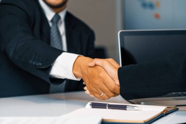 İş adamları konsepti kabul ediyor. İş adamı ve Asyalı iş kadını ofiste el sıkışırlar. uds