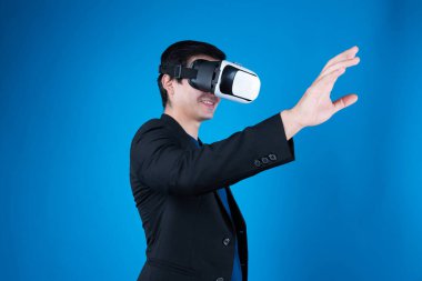 VR kulaklık takan profil işadamı, sanal gerçeklikte mavi arkaplan fütüristik teknolojisini izole eden ilginç verilerle slayta dokunarak metaevren aramasını bağlamaya çalışıyor. Entrika.