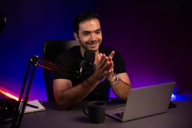 Yayıncı, fanclub dinleyicisiyle mikrofon kullanarak konuşuyor. Mor neon ışıklı modern stüdyoda yaratıcı olumlu düşünce konseptiyle canlı yayında finansal sorunları tartışıyor. Tahmin et..