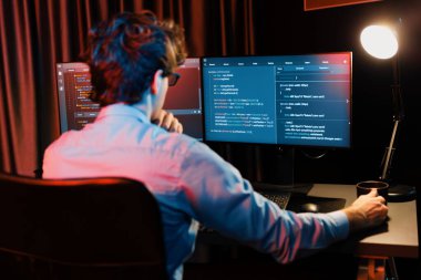 Uygulama pc ekranları ile çevrili çevrimiçi yazılım geliştirme bilgilerini yoğunlaştıran IT geliştiricisi, neon modern ofis evindeki web sitesinde yazılım için program yaratıyor. Toplayıcı.