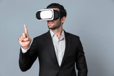 VR gözlük ve takım elbise giyerken veri analizine bakan yetenekli bir iş adamı. Proje yöneticisi görsel gerçeklik gözlüğü ya da kulaklık kullanırken kontrol ediyor ve seçiyor. Yenilik teknolojisi. Sapma.