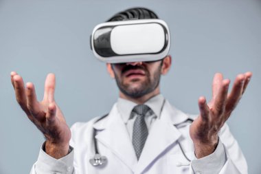 Tıbbi form tutarken VR gözlük ve laboratuvar önlüğü takan profesyonel bir doktor. Metastaz ya da sanal gerçeklik dünyasını hastalarla konuşmak ve onları iyileştirmek için kullanırken şekle bakan çekici bir doktor. Sapma.