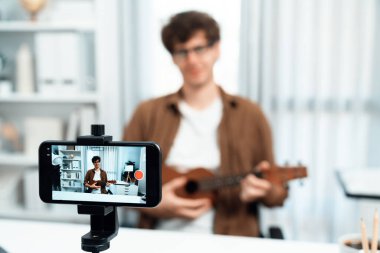 Nüfuzlunun sunucu kanalı, bulanık telefonda gitar çalarak şarkı söylüyor ve arka planda şarkıcı yayınlanıyor. Müzik blogcusu zaman aralığı ses yaratıcıda canlı sosyal medyada gösteriyor. Toplayıcı.