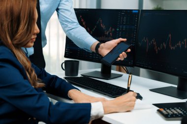 Kâr değeri değeri oranı online web sitesi uygulamasını ev ofisinde analiz etmek için notlar yazan kadınlara telefonda dinamik borsa verilerini gösteren bir işadamı eli kesilmiş. İnfobahn.