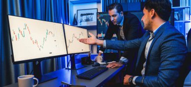 Borsa simsarları panorama manzaralı yüksek kar tablosu yatırımlarına bakıyor, geceleri monitörde analiz ediyorlar. İş yerinde finansal teknoloji gelişimini neon ışığında tartışma kavramı. Satılabilir.