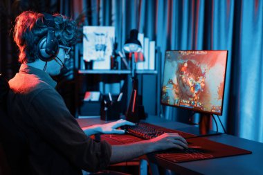 Savaş arenasında çoklu oyunlar takımıyla Moba 'da savaşan genç oyun flamasının sunucu kanalı, neon dijital ışık modern odasındaki arka görüntü ile bilgisayar monitöründe kulaklık takıyor. Toplayıcı.