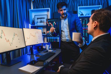 İki borsa simsarı gece monitörde döviz kurunda dinamik yatırım grafiğini tartışıyor. İş adamı ortakları iş yerindeki neon ışığı altında yüksek borsada kahve toplantısı yapıyor. Satılabilir.