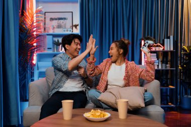 Çak bir beşlik yapan çift, modern evdeki neon ışıklı oturma odasında oturup video oyunu oynayarak birinci olacak. İnfobahn.