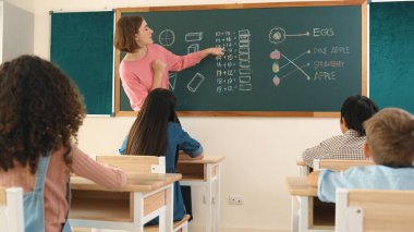 Zeki öğretmen sınıfta fikri açıklarken sevimli öğrenci ödevlerini kontrol ediyor. Not defterine bakıp matematik teorisinden çocuğa bahsederken sınıfta dolaşan çekici bir eğitmen. Pedagoji.