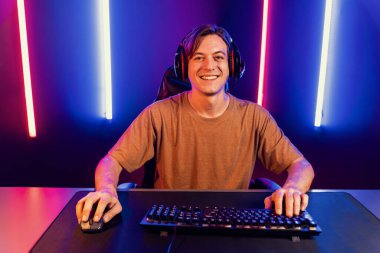 Kazanmak için çevrimiçi oyun oynayan akıllı flama makinesinin sunucu kanalı, neon ışıklı odada seçilen takım yarışması için izleyicilerle birlikte canlı yayında canlı yayında kulaklık takıyor. Bireysel.