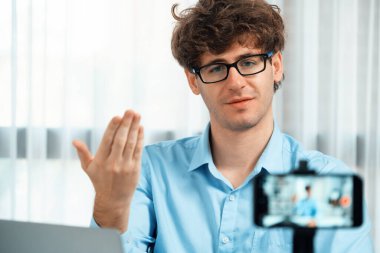 Etkilendiricinin sunucu kanalı akıllı telefon ile bulanık görüntü kullanır, satış ve pazarlama planlamasında çevrimiçi yayın yapar, modern ev ofisteki sosyal medya portresi üzerine odaklanır. Toplayıcı.