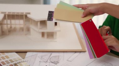 Mimari ekipman kullanan yavaş hareket eden iç mimar bir plan çizerken, iç mimari tasarımcı da müşterilerin talebine göre uygun renk ve malzeme seçiyor. Değiştirilmiş