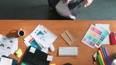 Akıllı iş adamının logo grafiği tasarlarken renk paletleri seçmesinin üst görünümü. Profesyonel iç mimar tasarımının hava görünümü ve renk paletleri kullanarak renk temasını seçin. Sempozyum.