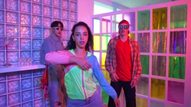 Değişik takımlarla dans ederken süslü gözlük takan yakışıklı hippi serbest stil müzikle mutlulukla dans ediyor. Beyaz hipster kulüpte parlak neon ışıkta sokak dansı yapıyor. Mutluluk.