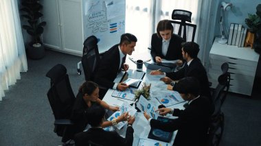 Toplantı odasındaki tabletin mali istatistik tablosuna bakan müdürün üst görüntüsü. Yatırım verilerini analiz etmek ve mali strateji planlamak için birlikte çalışan bir grup iş adamı. Müdürlük.