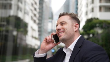 İş adamı, geçmişi bulanık bir telefonla finansal strateji hakkında yöneticiyle konuşuyor. Proje yöneticisi yatırımcıyı arıyor ve bulanık arkaplanlı pazarlama fikrini sunuyor. Yaşam tarzı. Urbane.
