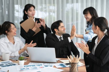 Bir grup mutlu iş adamı beşlik bir jest ve başarılı bir takım çalışması yapıyor. Çeşitli yarış bürosu çalışanları şirket ofisinde pazarlama planlamasında ilerleme kaydettikten sonra kutlama yapıyorlar. Habiliment