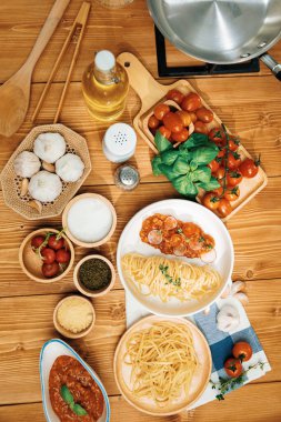 Lezzetli yiyeceklerin dikey üst görüntüsü ev yapımı spagetti hazırlama masası kıymalı domates sosu ve fesleğen fırlatma elementleri şef masasıyla servis ediliyor. Varsayım.