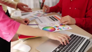 Dizüstü bilgisayarla çalışan grafik tasarım için beyin fırtınası yapan ve renk seçimi yapan tasarımcı takımının yavaş çekim çekimleri. Bu sırada müşteri de ofiste kromatik danışma sırasında projeyi denetliyor. Değiştirilmiş