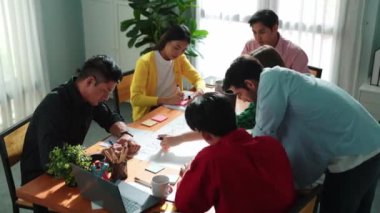 Top view of smart business team working together drawing mind map. Group of diverse people sharing marketing campaign or brainstorming idea and sharing plan by using colorful sticky notes. Convocation
