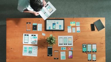 İş adamının toplantı odasında Ux Ui tasarımına bakması ve onu seçmesi. Yetenekli geliştirici yaratıcı iş yerinde cep telefonu arayüzü ya da yazılım uygulaması tasarlıyor ve planlıyor. Cemaat.