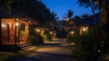 Mavi gökyüzü olan verimli bir tropikal bahçedeki kırsal kır evlerinin bulanık arka planı. Doğa fotoğrafçılığı. Sürdürülebilir yaşam ve sükunet kavramı. Çevre turizmi posteri ve tebrik kartı için tasarım. Aktar.