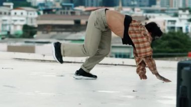 İspanyol break dansçı B-boy dansçısının ayak seslerini şehir manzaralı ya da gökdelenli çatıda pratik yapıyor. Genç modern dans grubu hip hop hareketi yapıyor. Tarz, moda, aksiyon. Açık hava sporu 2024 hiphop..