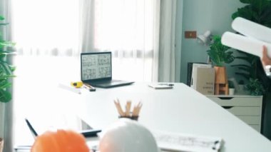 Taslak ve dizüstü bilgisayarda ayakta duran ve yazan akıllı bir mühendis. Mimarların elleri toplantı masasında ekipmanlarla birlikte yaratıcı bina inşaatını planlayıp düşünüyor. Hizalama.