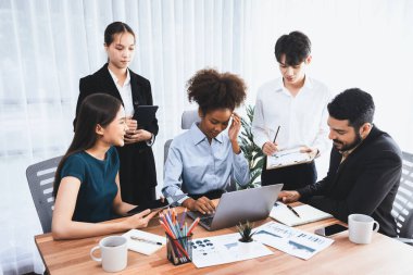 Çok ırklı analist ekibi toplantı masasındaki finansal verileri analiz etmek için BI Fintech yazılımı kullanıyor. Finansal konsol veri ekranında pazarlama göstergesi için analiz edilmiş grafikle birlikte. Uyum