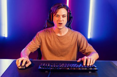 Kazanmak için çevrimiçi oyun oynayan akıllı flama makinesinin sunucu kanalı, neon ışıklı odada seçilen takım yarışması için izleyicilerle birlikte canlı yayında canlı yayında kulaklık takıyor. Bireysel.