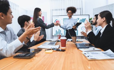 Çeşitli iş arkadaşları bunu şirket işyerinde el sıkışma ve takım çalışmasıyla kutluyor. Başarılı bir toplantıdan sonra el sıkışmayla ya da veri analizi üzerine iş sunumuyla birleşen mutlu iş adamları. Uyum