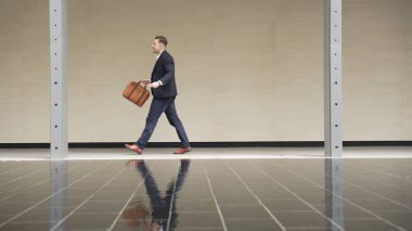 İş adamlarının bavul tutarken ve şehir merkezindeki iş yerine yürürken yan görüntüsü. Profesyonel proje yöneticisi dışarıda resmi takım elbise giyerken toplantıya gidiyor. Urbane.