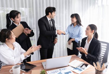 Bir grup iş adamı başarılı bir iş anlaşması toplantısı yaptıktan sonra el sıkıştı. Çeşitli yarış bürosu çalışanları şirket ofisinde pazarlama planlamasında ilerleme kaydettikten sonra kutlama yapıyorlar. Çok titiz.