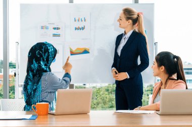 Çok kültürlü çalışma grubu. Farklı etnik kökenden iş kadınları, Kafkasyalı, Asyalı ve Araplardan oluşan bir ekip ofiste dizüstü bilgisayarla birlikte çalışıyor. Çok ırklı takım çalışması konsepti. uds