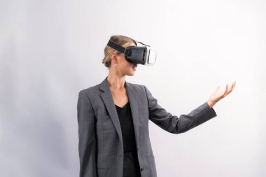 İş kadını, VR gözlük takıp beyaz arka planda dururken elinde bir şey tutuyor. Kulaklıklı proje yöneticisi görsel gerçeklik dünyasına teknolojik yenilikler kullanarak giriyor. Kısıtlanma.