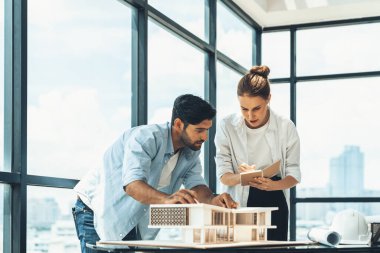 Akıllı beyaz mimar mühendis takımı ev modelini ölçmek için birlikte çalışıyor. Bir grup profesyonel iç mimar tasarım inşaatı hakkında fikir paylaşımı ve beyin fırtınası yapıyor. İzleme.