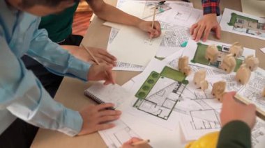 Mimari belge, ölçüm aracı ve ahşap blokların modern ofiste etrafa saçıldığı bir masa üzerinde yapı inşaatı ile ilgili mimar ve güvenlik mühendisi tartışması. Tanımlama.