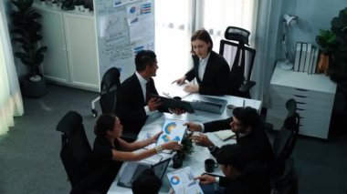 Toplantı odasındaki tabletten finansal istatistiklere bakan akıllı yöneticinin en üst görüntüsü. Masadaki yatırım verilerini not defteriyle analiz etmek için birlikte çalışan bir grup iş adamı. Müdürlük.