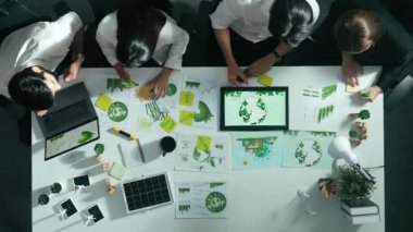 Yönetici yöneticisinin üst görünümü toplantılarda tablet temiz enerji gösterir. İş adamlarının sürdürülebilir çevre yatırımlarını planlamak ve yatırım yapmak için birlikte çalıştıklarına dair havadan bir bakış açısı. Hizalama.