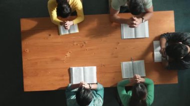 Akıllı takımın yukarıdan görünüşü kutsal İncil 'e ve toplantı masasında otururken dua eden tanrıya el ele tutuşuyor. Bir grup insan inanç, maneviyat ve dinle dua ederek el üstünde toplandı. Sempozyum.